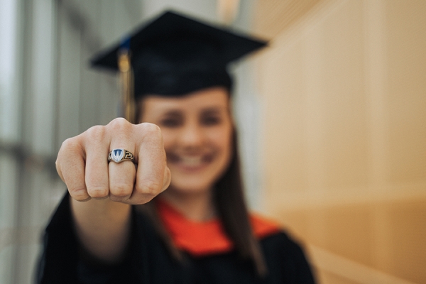 grad holding out hand wearing class ring