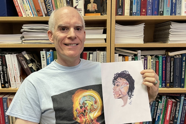 Dave Andrews holding illustration of anatomy