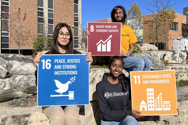 students holding signs with examples of Sustainable Development Goals