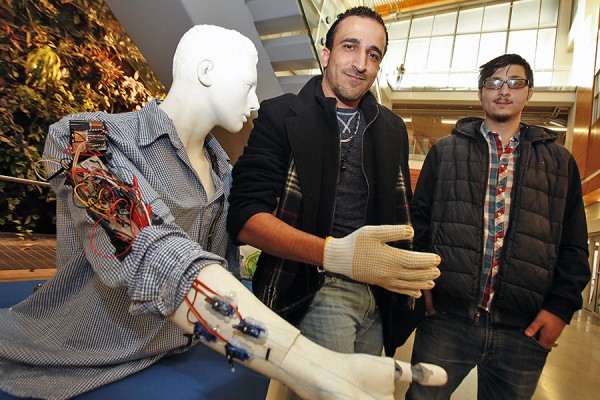 Engineering students Mohammad Kaddouh and Mohanad Elkafarneh demonstrate the robotic arm they designed and built.