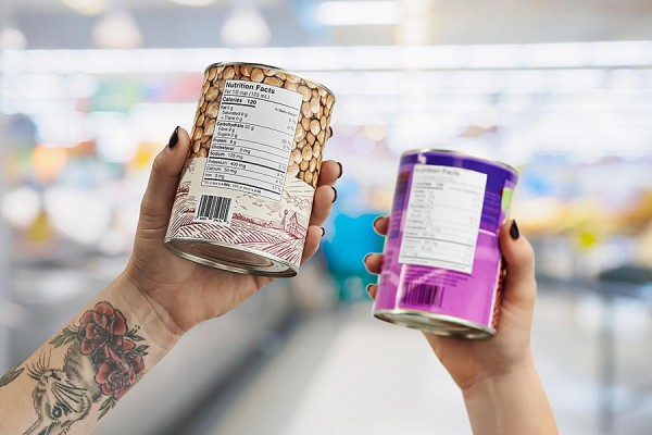 hands holding canned goods to display nutrition labels