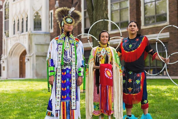 Indigenous students in traditional dress on lawn of Dillon Hall