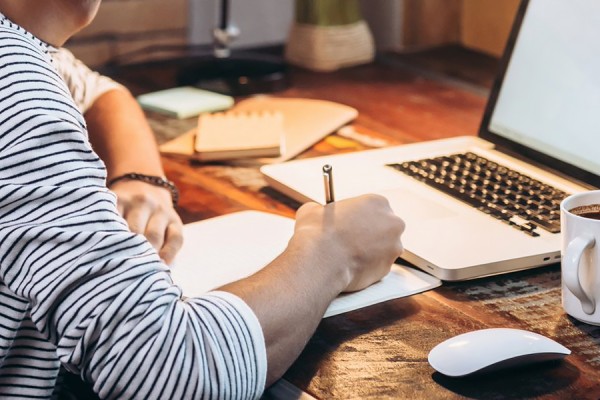 person working at desk, laptop, coffee mug