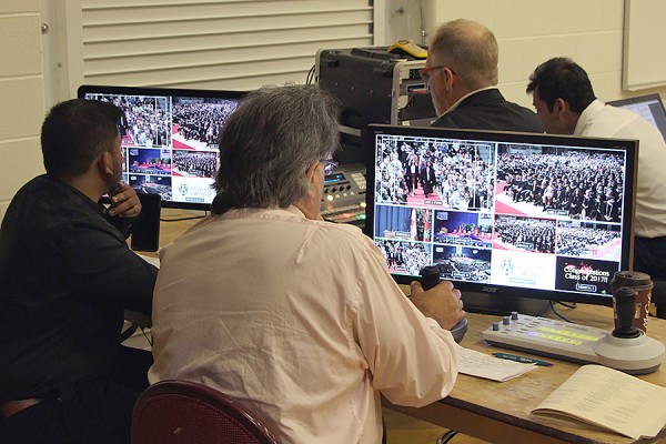 Staff of Media and Educational Technologies work backstage during Convocation to record the event.