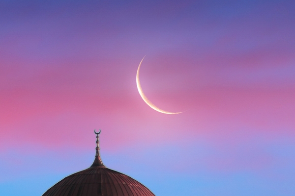 new moon in sky over mosque