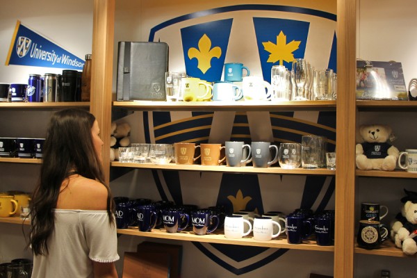 Third-year nursing student Nicole Preston admires some of the new UWindsor branded giftware available at the Campus Bookstore.