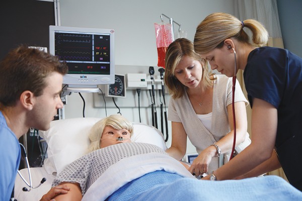 students and instructor work with mannequin simulator