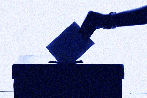 hand placing ballot in box