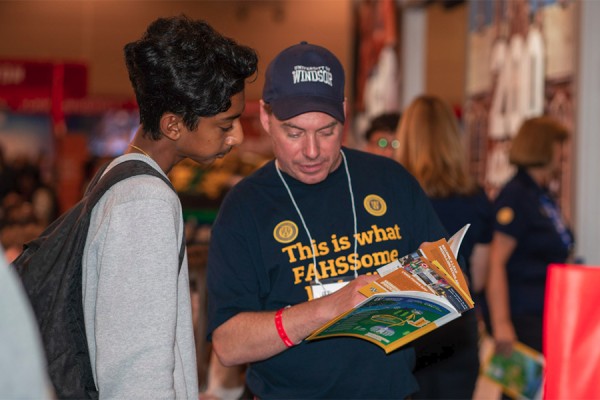 Professor Michael Darroch of the School of Creative Arts promotes its programs to a visitor at the UWindsor booth during the Ontario Universities Fair.