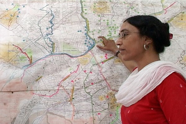 Perween Rahman standing in front of city map