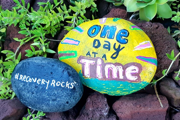 stone painted with slogan &quot;One Day at a Time&quot;