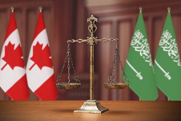 scales of justice before Canadian and Saudi flags