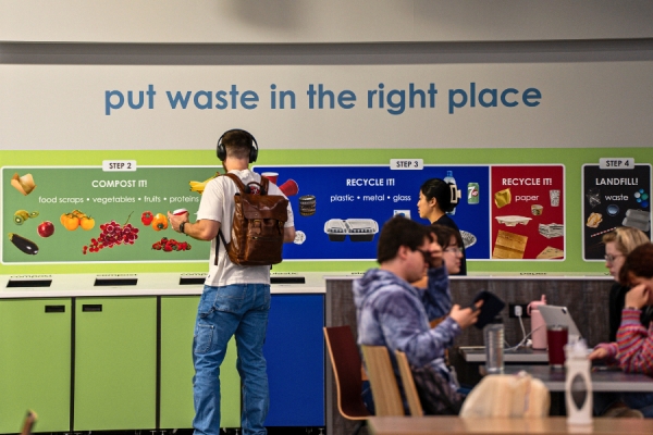 students sorts recycling materials in cafeteria