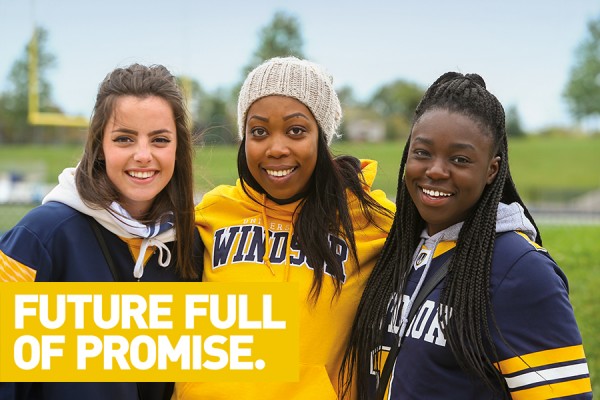 Students smiling behind banner reading: Future full of promise