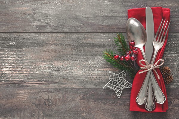 table set with cutlery and sprigs of greenery