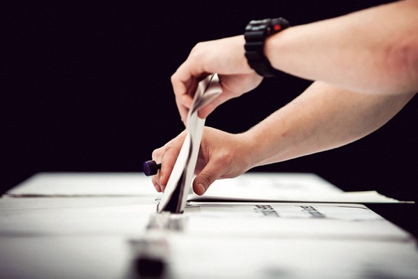 hand placing ballot in box