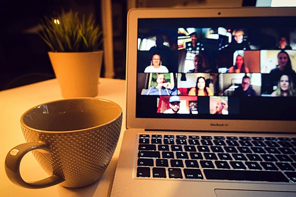 Coffee cup next to laptop computer