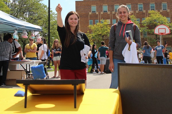 Kaitlyn Hand tosses a bean bag just past the target as classmate Jessica Szawara looks on