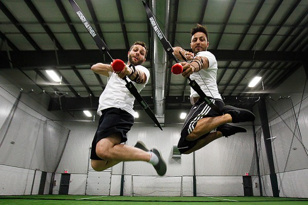 Samer Toukan, Easa Ahmadzai jump in the air holding arrows notched in bows