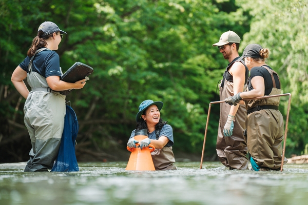 Catherine Febria with reserach team in hip waders in water