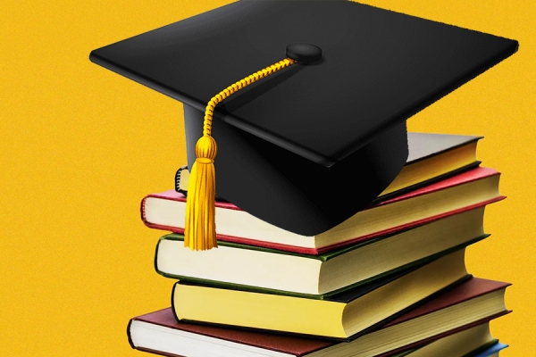 mortarboard balanced on pile of books