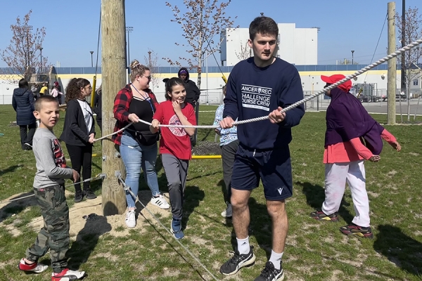 Robbie Oates guides Begley school children through the low ropes course.