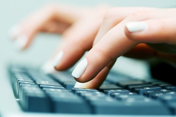 hands typing on computer keyboard