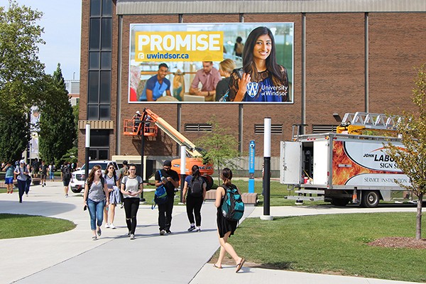 giant banner bearing image of student and words Promise@UWindsor