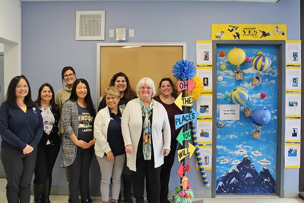 Staff of Co-operative Education and Workplace Partnerships pose with their winning door decorations at the entrance to Room 1100, Lambton Tower.