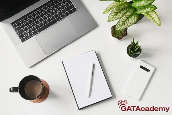 Photo of laptop, notepad and accessories on a desk.