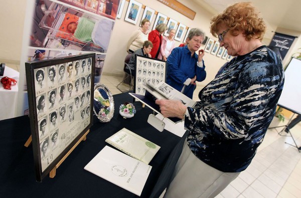 Shirley Whitfield flips through a year book during a ceremony to introduce the newly created digital archive of the Metropolitan General Hospital School of nursing archives at Windsor Regional Hospital. Photo credit: Tyler Brownbridge/The Windsor Star.
