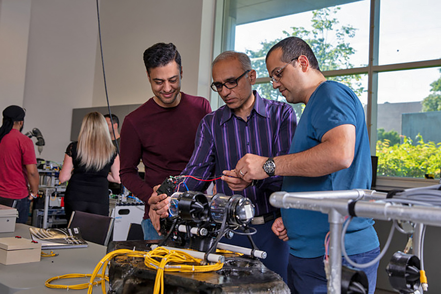 researchers bent over aquatic drone