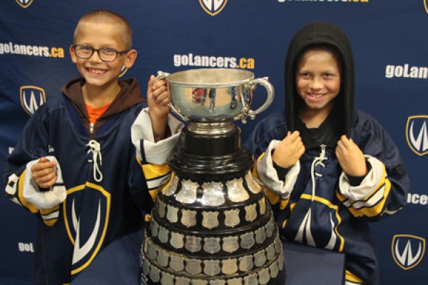 Devin and Ethan Poupard pose with the Queen’s Cup