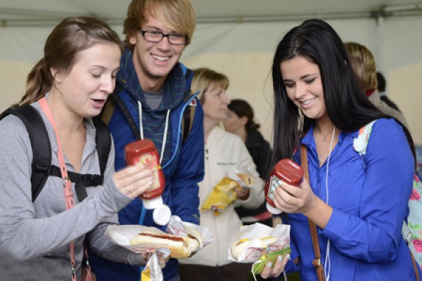 students pour ketchup on sausages