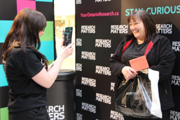 Dusty Johnstone photographs a visitor to the Research Matters Curiosity Shop.