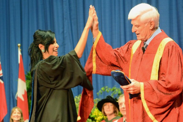 BComm grad Maisa Al-Nawawreh high-fives chancellor Ed Lumley.