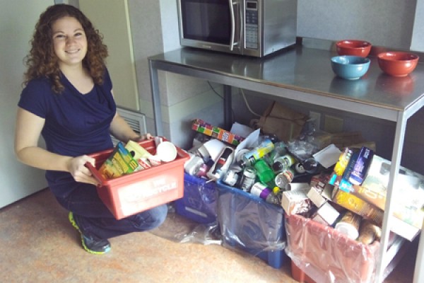 Meghan Riddell empties a container of recyclables