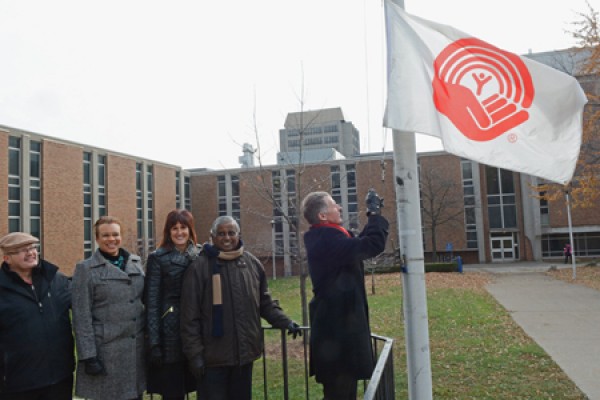 UWindsor president Alan Wildeman raises the United Way flag. 