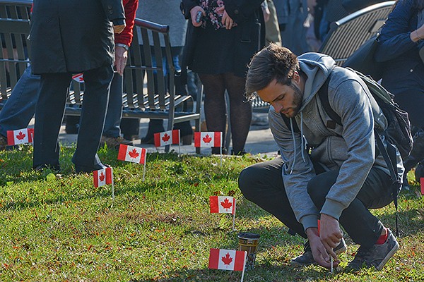 student plants a flag in the lawn