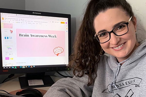 BCNSA vice-president Alyssa Arundine seated before computer screen displaying &quot;Brain Awareness Week&quot;