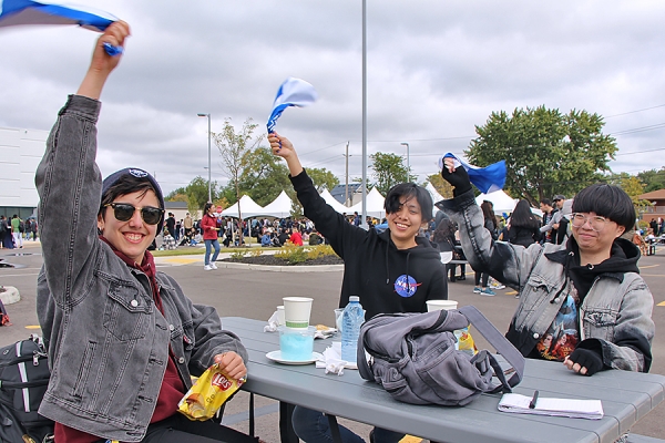 students cheering at barbecue table