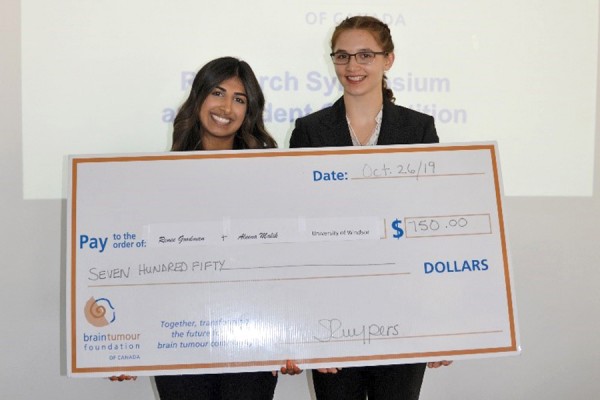 Aleena Malik, Renée Goodman holding oversized cheque