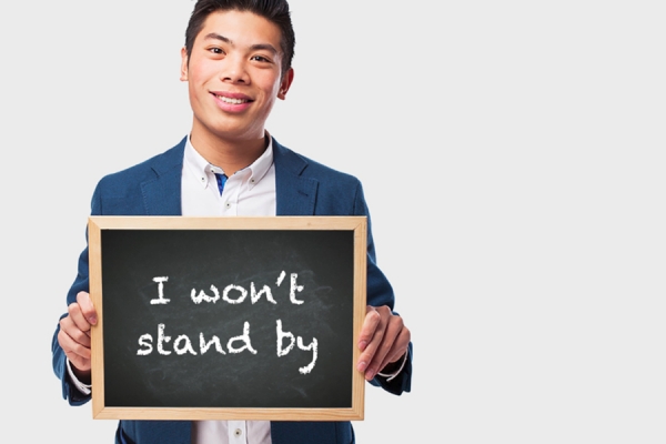 Man holding sign that reads &quot;I won&#039;t stand by&quot;