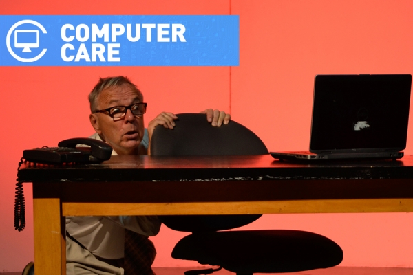 man cowering behind computer screen