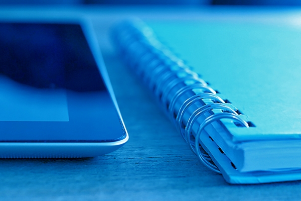 tablet computer and spiral bound notebook