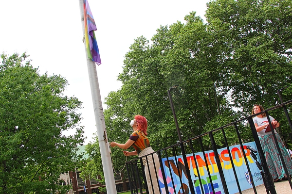 Yufei Qin hoists a rainbow flag