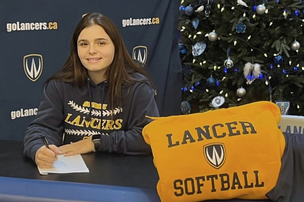 Jacqueline Pento posing with Lancer softball pillow