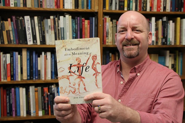 Jeff Noonan holding book, “Embodiment and the Meaning of Life.”