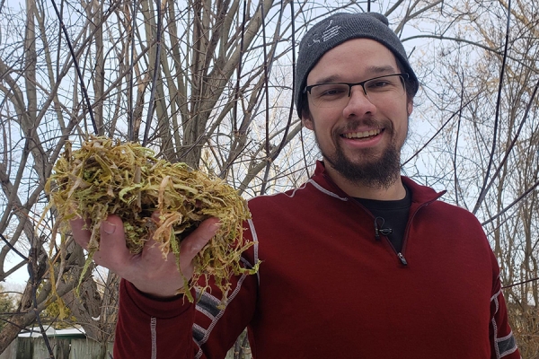 Joe Pitawanakwat holding plant material