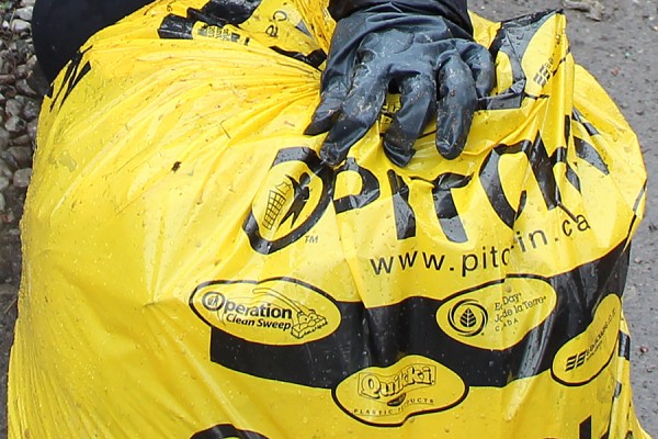 gloved hand holding trash bag